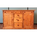 A late Victorian pine country dresser base, six drawers flanked by two cupboards,
