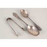 Two silver spoons plus a pair of silver tongs,