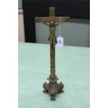 A brass alter cross on a triform footed base,