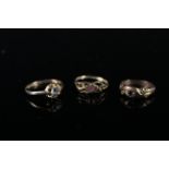 Three 9ct gold rings, one with horse shoe and riding crop detail, one set with paste stone,