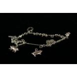 A yellow metal charm bracelet with various charms including a pig, St Christopher,