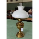 A vintage brass oil lamp with white glass shade