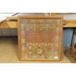 A framed sampler with central verse and decorative border by Elizabeth Rauce,