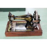 An early 20th Century Singer hand crank sewing machine in wood case