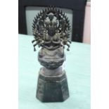 An antique metal figure of a Buddha on a wooden base,