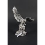 A filled silver model of an eagle perched on a tree stump (some damage to one wing)