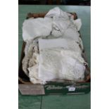 A box of mixed antique linens and lace work including a number of antique lace blouses and night