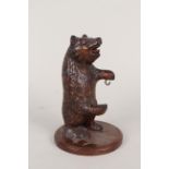 An early 20th Century Black Forest carved bear pocket watch stand with glass eyes and open mouth,