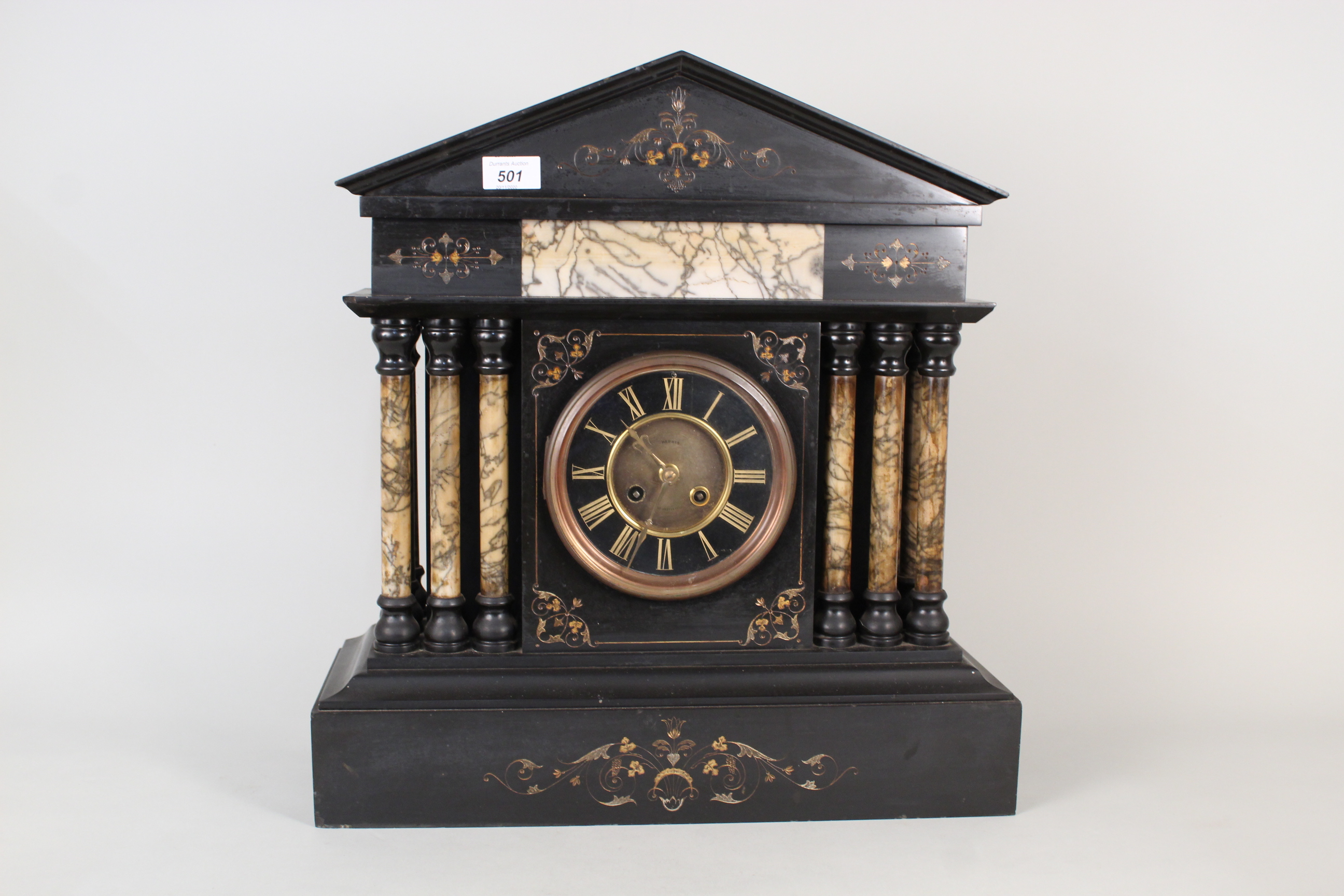 A substantial black marble mantel clock with gilt painted decoration and pale marble columns