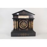 A substantial black marble mantel clock with gilt painted decoration and pale marble columns