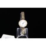 A lady's 9ct gold porcelain dialled wristwatch with rolled gold strap