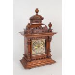 An Edwardian walnut brass faced mantel clock,