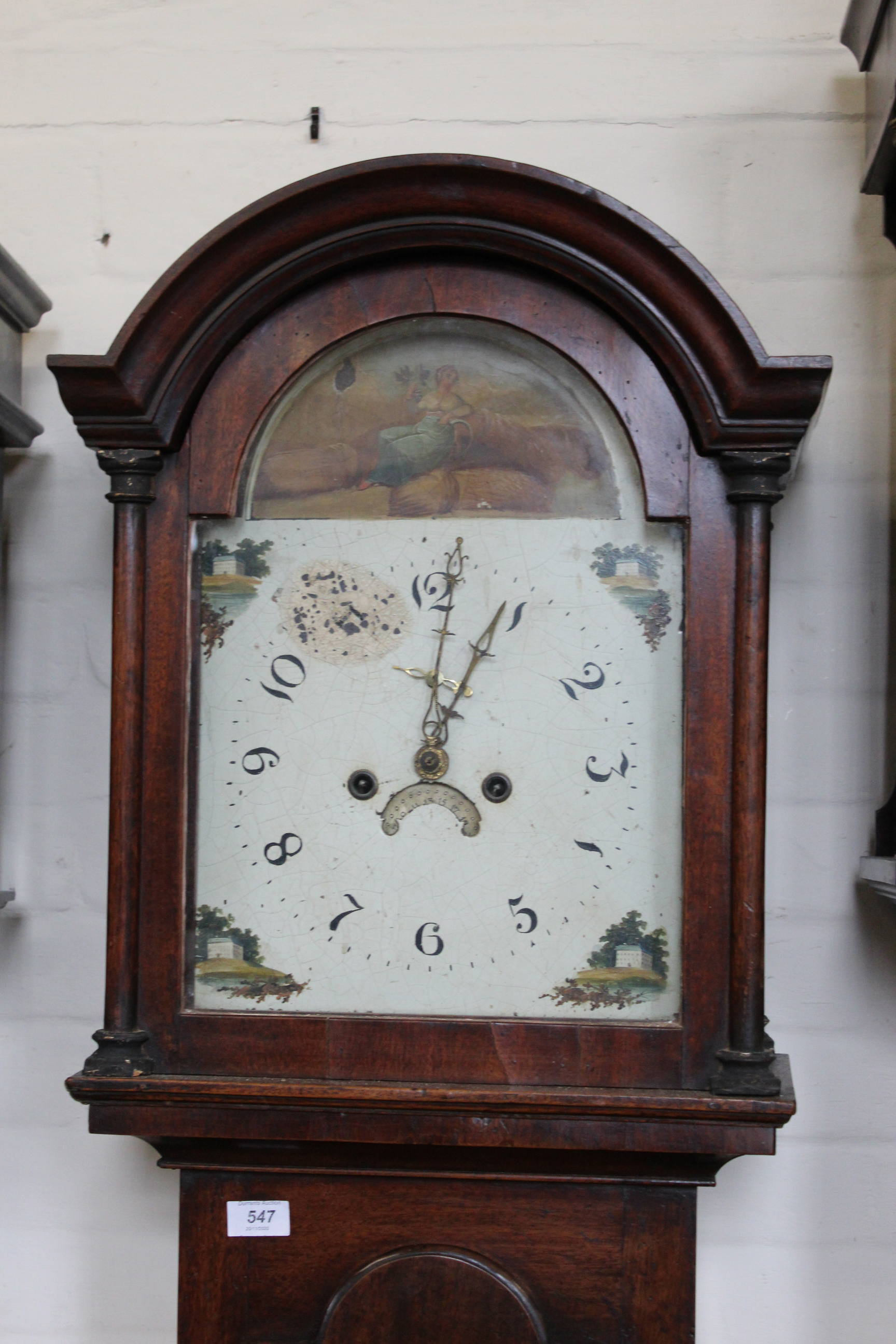 An early 19th Century mahogany arch dial cottage long case clock with painted face,
