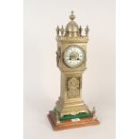 A cast brass clock in the form of a long case clock, porcelain dial with striking movement,