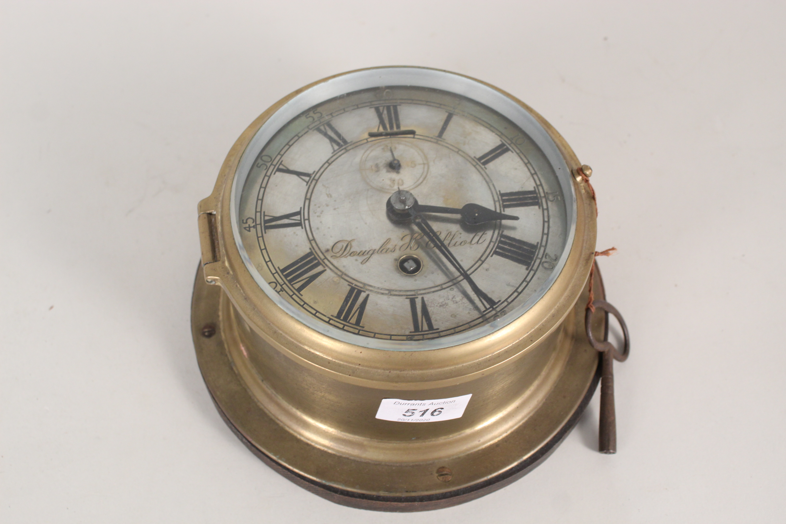 A brass ships clock on an oak base,