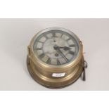 A brass ships clock on an oak base,