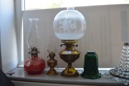 Three Oil Lamps and a Green Glass Shade