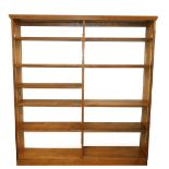 An oak open bookcase, the pediment over a centrally divided set of 10 shelves raised on a plinth