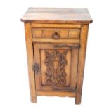 An oak pot cupboard, with a canted rectangular top, over a frieze drawer, above a carved panelled