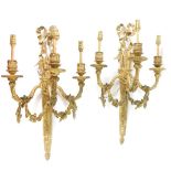 A pair of Adam style brass three branch wall lights, cast as a quiver of arrows with bow surmount,