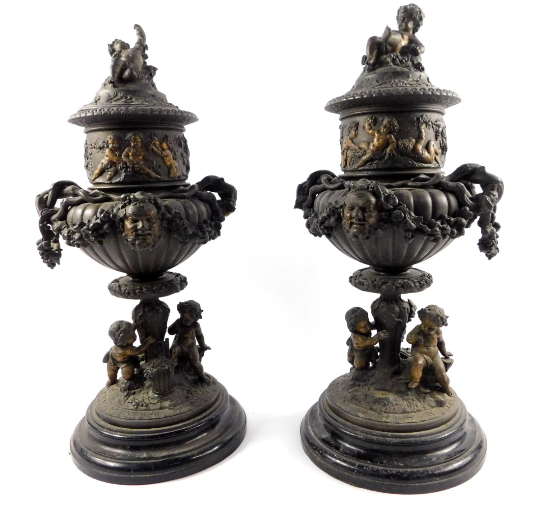 A pair of late 19thC Continental spelter urns and covers, of twin handled semi fluted form, cast