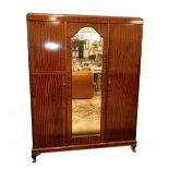 An early 20thC mahogany compactum wardrobe, the domed pediment over three doors, the central door