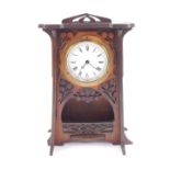 An Art Nouveau wooden cased mantel clock, circular enamel dial bearing Roman numerals, clockwork