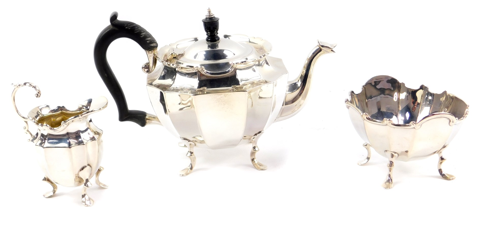 A George V silver three piece tea set, of fluted form, raised on four cabriole legs, comprising