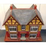A vintage mid 20thC wooden doll's house, double bay and forecourt, with a triple roof, rear entry,