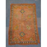 An Oushak rug, with multi medallion centre on a madder ground, with blue banded triple border, 200cm