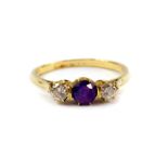 An 18ct gold diamond and amethyst three stone ring, diamonds approx 0.5cts, size R, 3.0g.