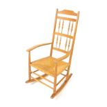 A Neville Neal ash rocking chair, after a design by Ernest Gimson, with a spindle turned back and