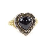 A Georgian heart shaped garnet and diamond ring, with a cabachon garnet in a surround of old cut