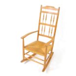 A Neville Neal ash rocking chair, after a design by Ernest Gimson, with a spindle turned back and