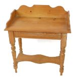 A Victorian pine washstand, with a galleried top, raised on turned and fluted legs united by