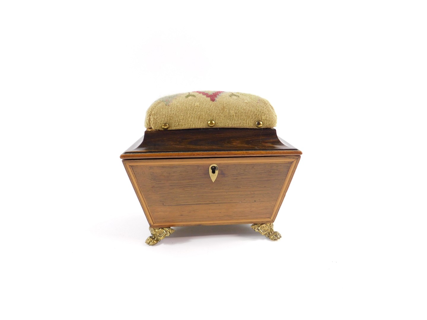 A Regency rosewood sewing casket, of sarcophagus form, with satinwood cross banding, the tapestry