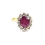 An 18ct ruby and diamond ring, the oval cut ruby, approx 3.5cts, in a surround of twelve diamonds,