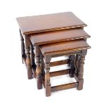 A Reprodux oak nest of occasional tables by Bevan Funnell Ltd, raised on turned supports united by