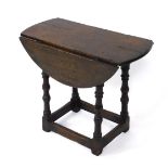 A 17thC style oak drop leaf occasional table, raised on baluster turned supports, united by