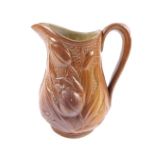 A late 19thC Staffordshire relief moulded jug, brown glazed moulded with flowers, 18cm H.
