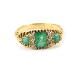 An 18ct gold emerald and diamond three stone ring, set with three cushion shaped emeralds,