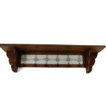 A Victorian pine wall hanging coat rack, with six floral tiled back and six hooks, 31.5cm H, 125cm