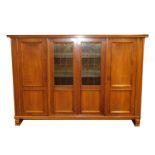 A Continental mid 20thC walnut linen press, with two glazed central doors flanked by two further