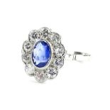 A sapphire and diamond cluster ring, with central oval cut pale blue sapphire, in rub over