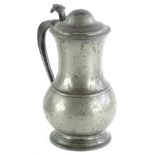An 18thC baluster shaped pewter lidded tankard, with engraved thumb piece and domed cover, the