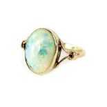 An opal dress ring, with oval cut opal stone, and v split design shoulders, in yellow metal setting,