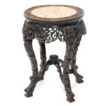 A late 19th/early 20thC Chinese hardwood urn stand, the circular top carved with vines and