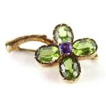 A modern 9ct gold four leaf clover brooch, set with four peridots and one amethyst stone, in the