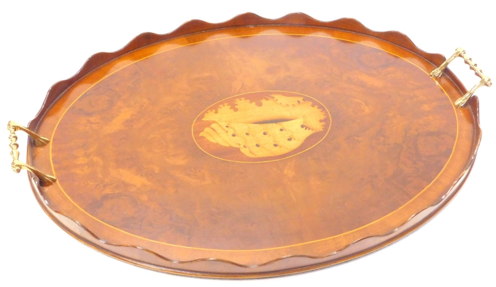 A burr walnut oval galleried tray, inlaid centrally with a shell with brass handles, 60cm W.