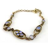 A gilt metal and imitation moonstone bracelet, with floral cluster and elongated type design centre,